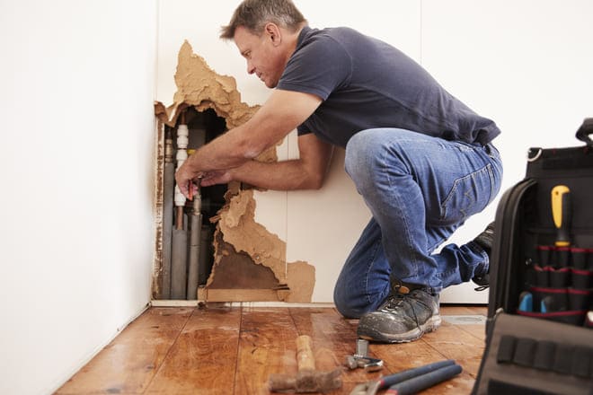 homem reparando tubulação 